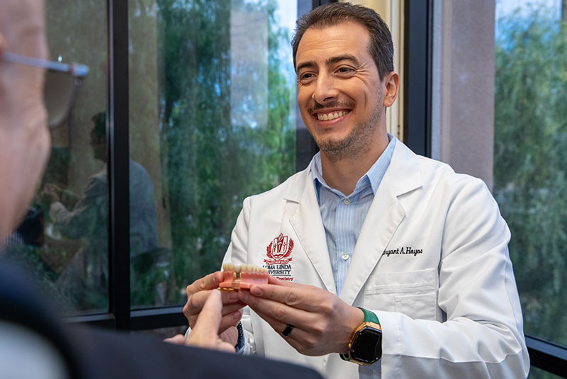 doctor showcasing full arch model to patient within the dental center