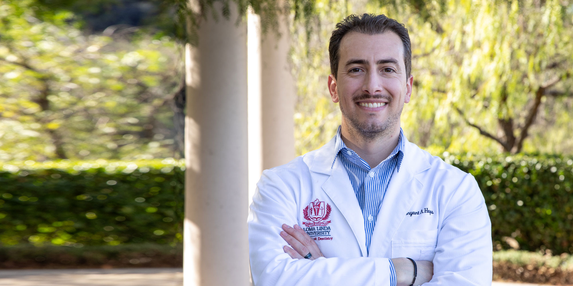 headshot of doctor smiling outside of the dental center