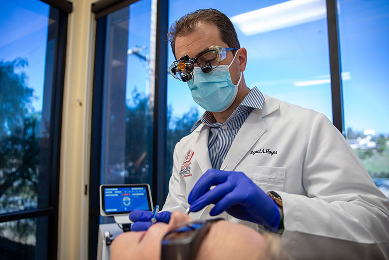 doctor performing oral procedure treatment on patient