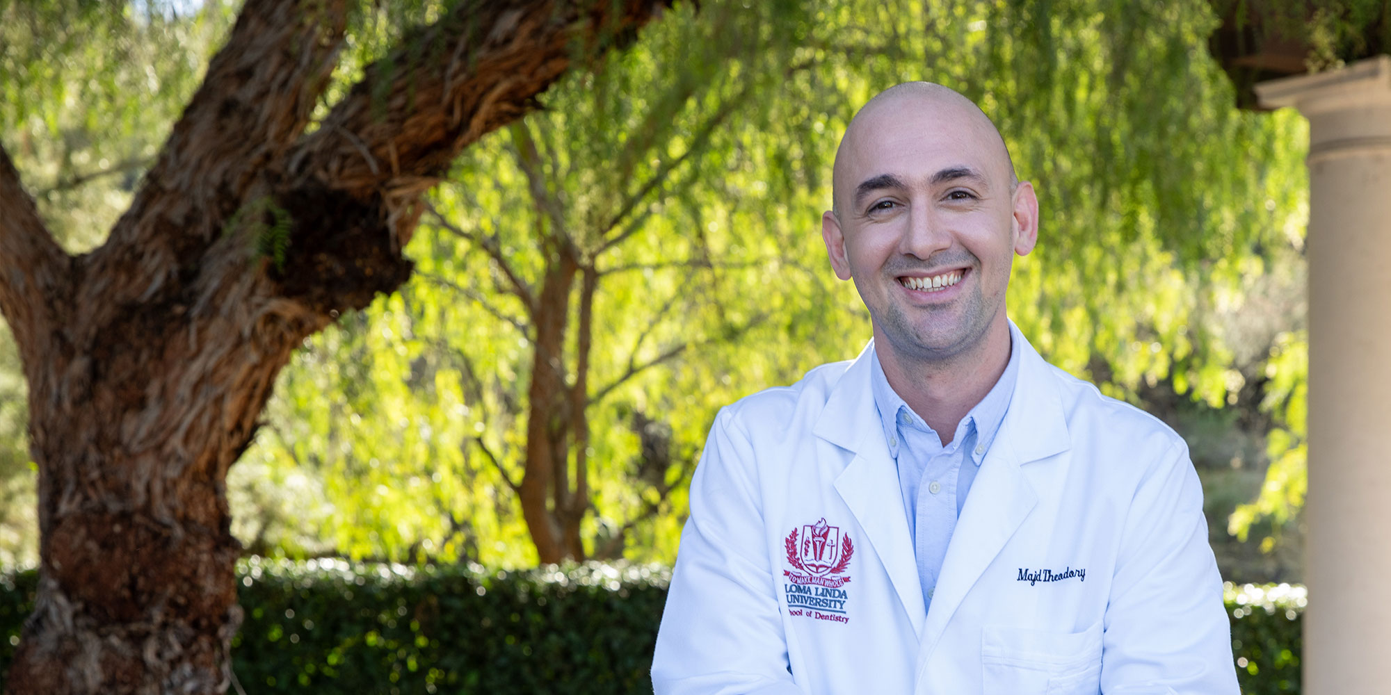 headshot of doctor smiling outside of the dental center