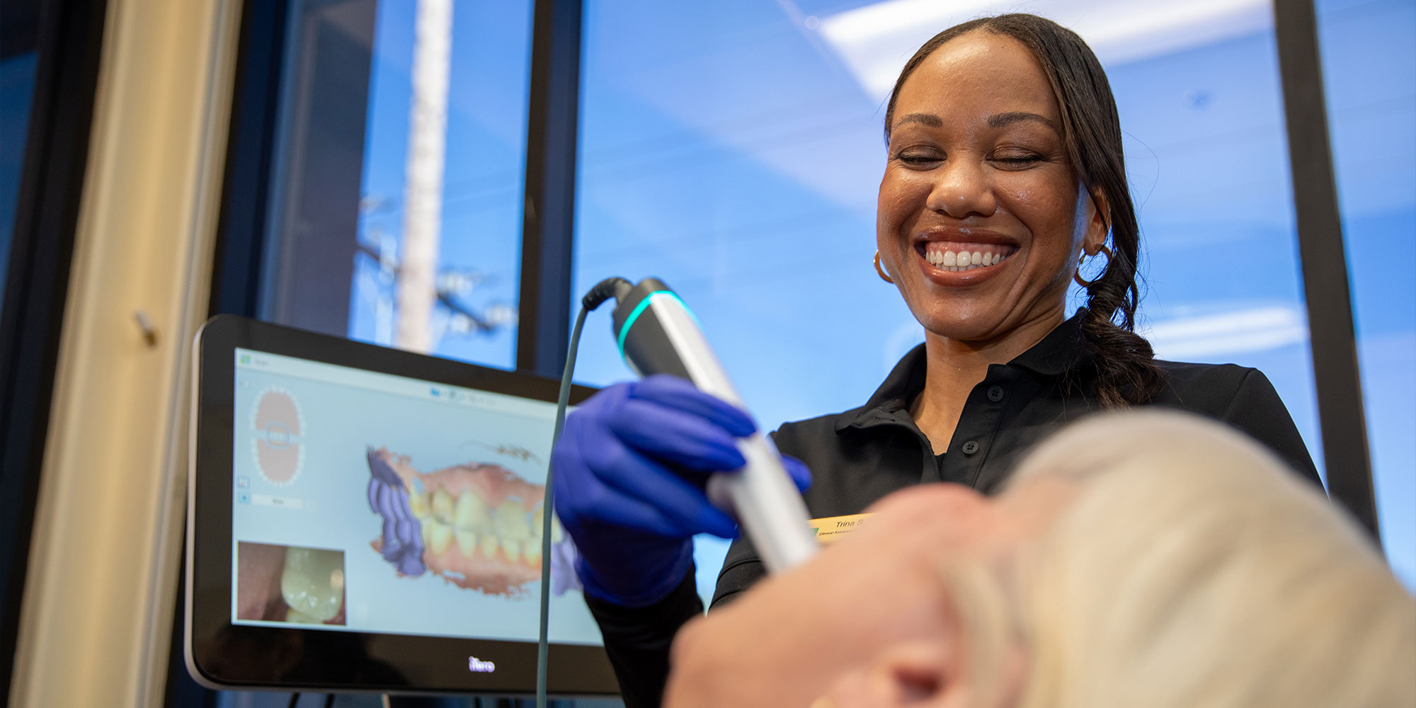 staff member examining patient for their dental treatment