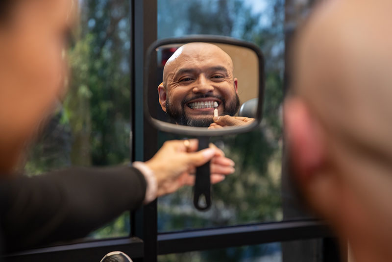 patient having a model veneer being compared for treatment