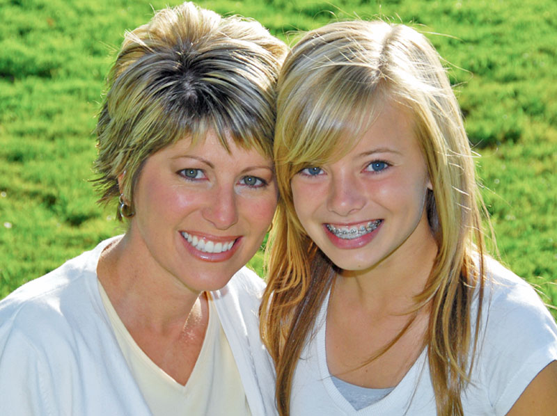 Mother and teen daughter smiling.