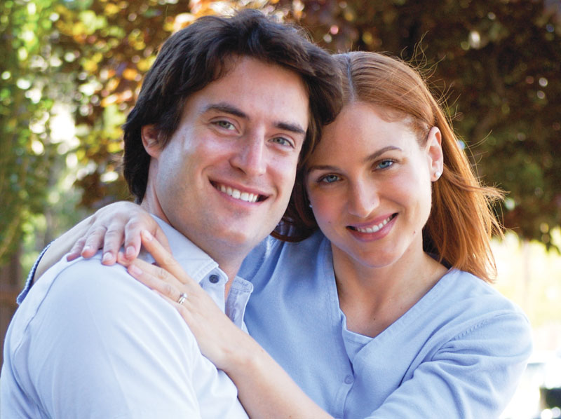 A young couple smiling.